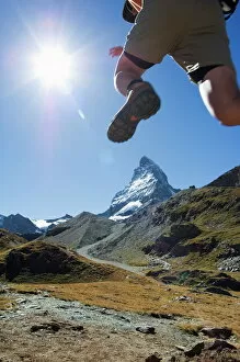 Hiker running on trail and the Matterhorn