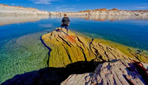 55 59 Prints: A hiker standing on a rock peninsula at Lake Powell, Arizona, United States of America