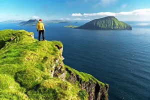 Mid Adults Prints: Hiker stands on top of a cliff admiring the rugged view