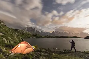 The Great Outdoors Prints: Hiker and tent on the shore of Lacs De Cheserys at night with Mont Blanc massif in background