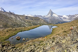 Hikers admire the Matterhorn reflected in Lake Stellisee, Zermatt, Canton of Valais