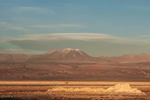 Salt Flat Prints: Hikers out on the Atacama Salt Flats, with snow-capped volcanic peak in the background