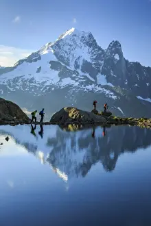 Trekking Prints: Hikers on the shores of Lac de Cheserys, with Aiguille Verte reflected at dawn, Chamonix