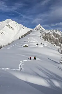 Valchiavenna Prints: Hikers trying to approach the little village at the Scima Alp covered in snow