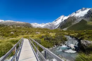 A hiking trail crosses wooden bridge over a creak high up in the mountains, South Island