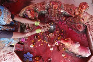 Celebration Gallery: Hindu woman worshipping a lingam during Holi celebration in Goverdan, Uttar Pradesh