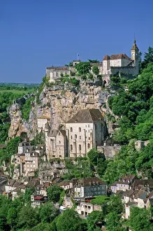 Lookout Prints: Historic buildings on a cliff in Rocamadour with trees and clear blue sky in France