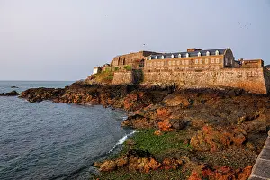 Guernsey Prints: Historic Castle Cornet stands on coastal rocks at low tide near St Peter Port in Guernsey Channel Islands