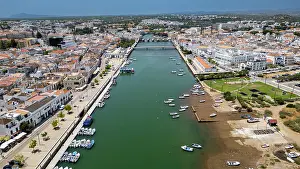 Streets Prints: Historic city of Tavira reveals boats along the river and architecture among white buildings in Portugal