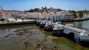 Planning Prints: Historic city of Tavira is viewed from above with old buildings and a bridge by the river in Portugal under clear skies