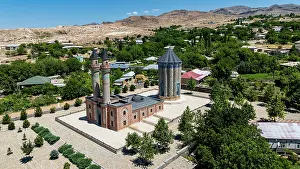Tall Prints: Historic mausoleum stands tall in Garabaghlar with surrounding trees and homes visible in Nakhchivan