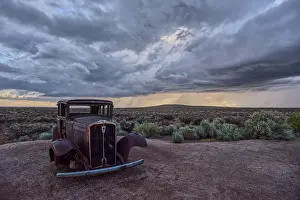 Dust Prints: Historic Model-T marks Route 66 in Petrified Forest National Park as storm clouds gather over Arizona landscape