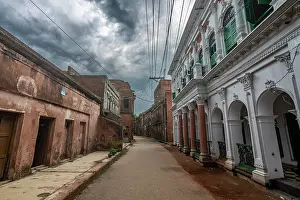 Overcast Prints: Historic Panam City street lined with old buildings under cloudy sky in Bangladesh