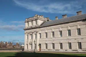 Windows Prints: Historic Queen Anne Court Building viewed from an open area with clear skies in Greenwich London