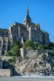 Geography Prints: Historic site Mont St. Michel rises above the landscape on a clear day in France with visitors exploring the area