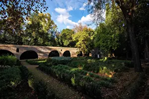 Granada Prints: Historic stone bridge surrounded by gardens in Granada Spain