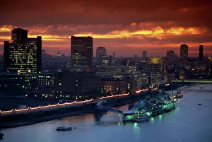 HMS Belfast moored on the Thames, illuminated at dusk, London, England