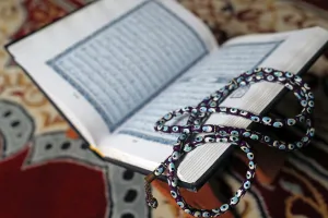 Hanoi Prints: Holy Quran in Arabic and Muslim prayer beads on wood stand, Vietnam, Indochina