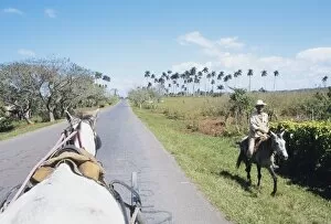 Images Dated 17th June 2010: Horse carriage passes farmer on horseback, Vinales, Pinar del Rio, Cuba