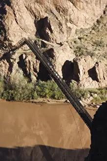 Horses and tourists crossing a suspension bridge spanning