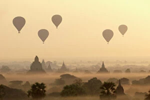 Ethereal Gallery: Hot air ballons fly over ancient temples at dawn in Bagan (Pagan), Myanmar (Burma), Asia