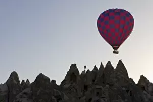 Hot air balloon taking off with tourists on board for a flight over the famous volcanic tufa rock formations around
