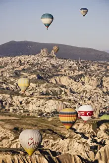 Asia Minor Prints: Hot air balloons flying among rock formations at sunrise in the Red Valley