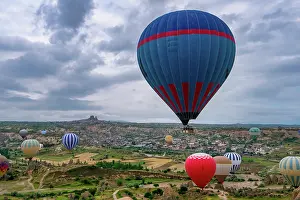 Friendship Prints: Hot air balloons rise over Cappadocia at sunrise with Ortahisar city in the background in Turkey