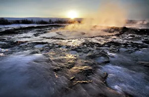 Glowing Prints: Hot pools and steam from Strokkur Geysir at sunrise, winter, at geothermal area beside