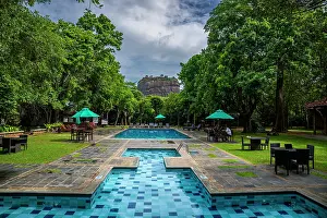 Province Prints: Hotel pool area surrounded by trees with view of ancient rock fortress in Sri Lanka