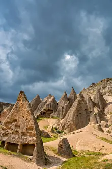 Cappadocia Prints: Houses carved into rocks of Selime ancient town in Cappadocia, Turkey under a cloudy sky