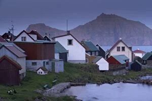 Houses at Gjogv at twilight, with view of Kalsoy cliffs of Nestindar, 788m