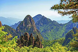Pristine Prints: Huangshan in Anhui Province shows mountain peaks and green forests with clear skies under bright sunlight