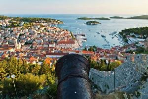 Protection Gallery: Hvar Fortress cannon and Hvar Town at sunset taken from the Spanish Fort (Fortica), Hvar Island