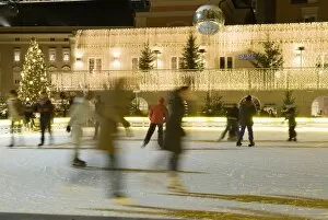 Ice skating at night on ice rink at Mozartplatz square, Salzburg, Austria, Europe