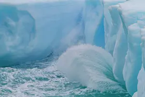 Glacial Prints: Iceberg detail shows blue tones in water with waves during Austral summer near Antarctic Peninsula