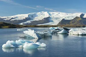 Icebergs floating on Jokulsarlon Glacial Lagoon with Hvannadalshnukur Peak in the background