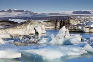 Icebergs in Jokuls arlon glacial lagoon, Breidamerkurjokull (Vatnajokull) glacier in the dis tance