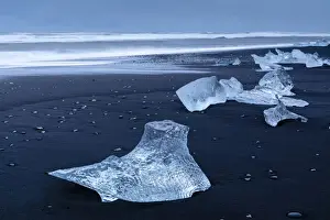 Icebergs from melting glacier on black sand beach near Jokulsarlon glacier lagoon, Vatnajokull National Park, Iceland