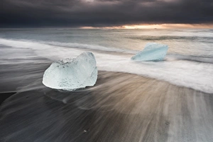 Icebergs at sunrise on Jokulsarlon Beach, a black volcanic sand beach in South East Iceland