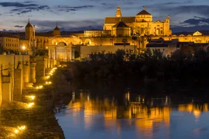 Moorish Prints: The illuminated mosque-cathedral and the Roman bridge at dusk, Cordoba, Andalusia