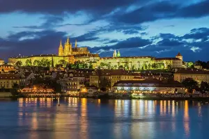 Riverfront Prints: Illuminated Prague Castle rising above Vltava River at twilight