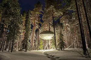 Harads Prints: Illuminated UFO shaped room in the frozen forest covered with snow