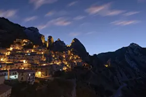 Illuminated village of Castelmezzano framed by Dolomiti Lucane peaks at sunrise
