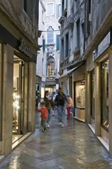 Illuminated window displays in small street, San Marco, Venice, Veneto, Italy, Europe