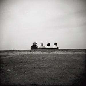 Monochrome Gallery: Image taken with a Holga medium format 120 film toy camera of four people on a bench overlooking the sea