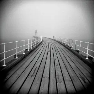 Misty Prints: Image taken with a Holga medium format 120 film toy camera looking along timber boardwalk of Whitby pier on misty