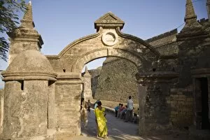 An Indian woman in a sari walks through the gate leading to the Fortress in Diu