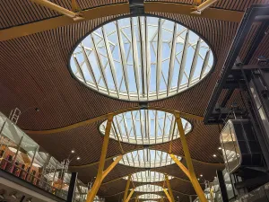 Bustling Prints: Interior view of an airport terminal showcasing modern design and large skylights in Madrid
