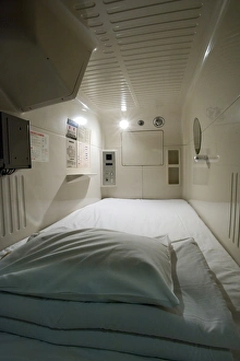 Interior view of single-person sleeping compartment at capsule hotel in Osaka Interior view of single-person sleeping compartment at capsule hotel in Osaka
